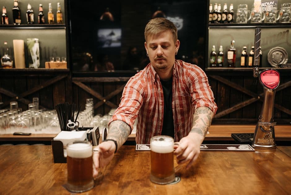 Barra de un bar con el camarero sirviendo cerveza