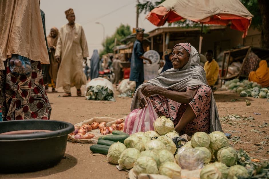 Cheerful vendor selling fresh produce at an African open market
