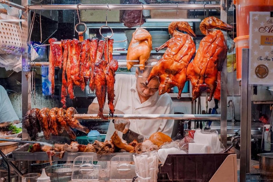 Singapore hawker stall display of roasted meats and cooked food