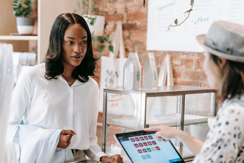 Retailer comparing point of sale apps on a tablet in an African shop