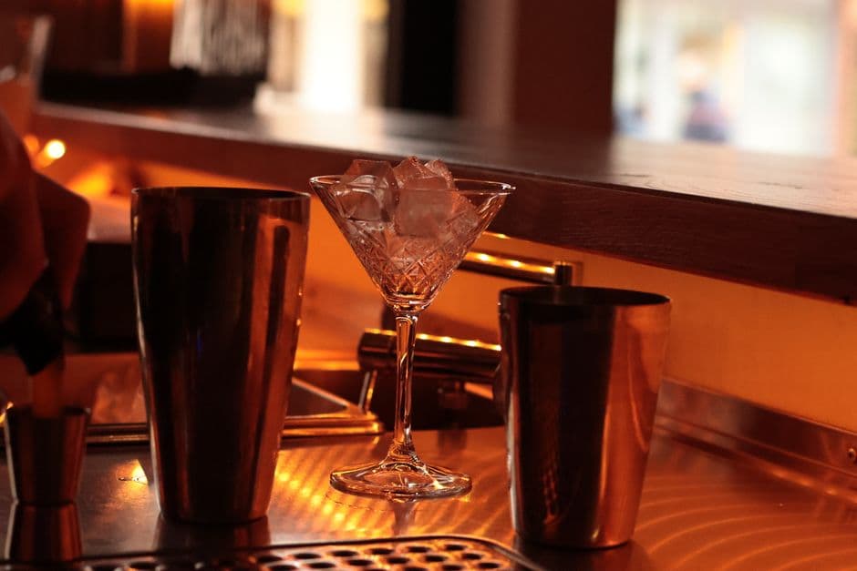 Drinks lined up on a busy lounge bar counter at night